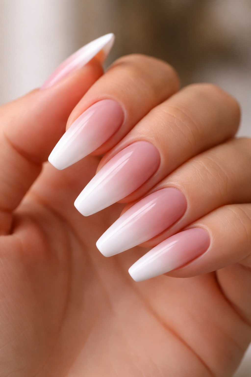 Close-up of baby boomer white fade on a ballerina-shaped nail