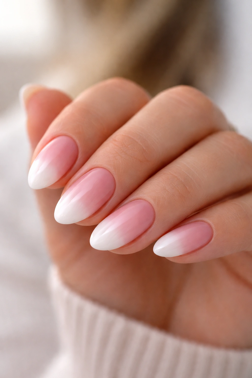 Close-up of short almond nails with pink-to-white baby boomer fade