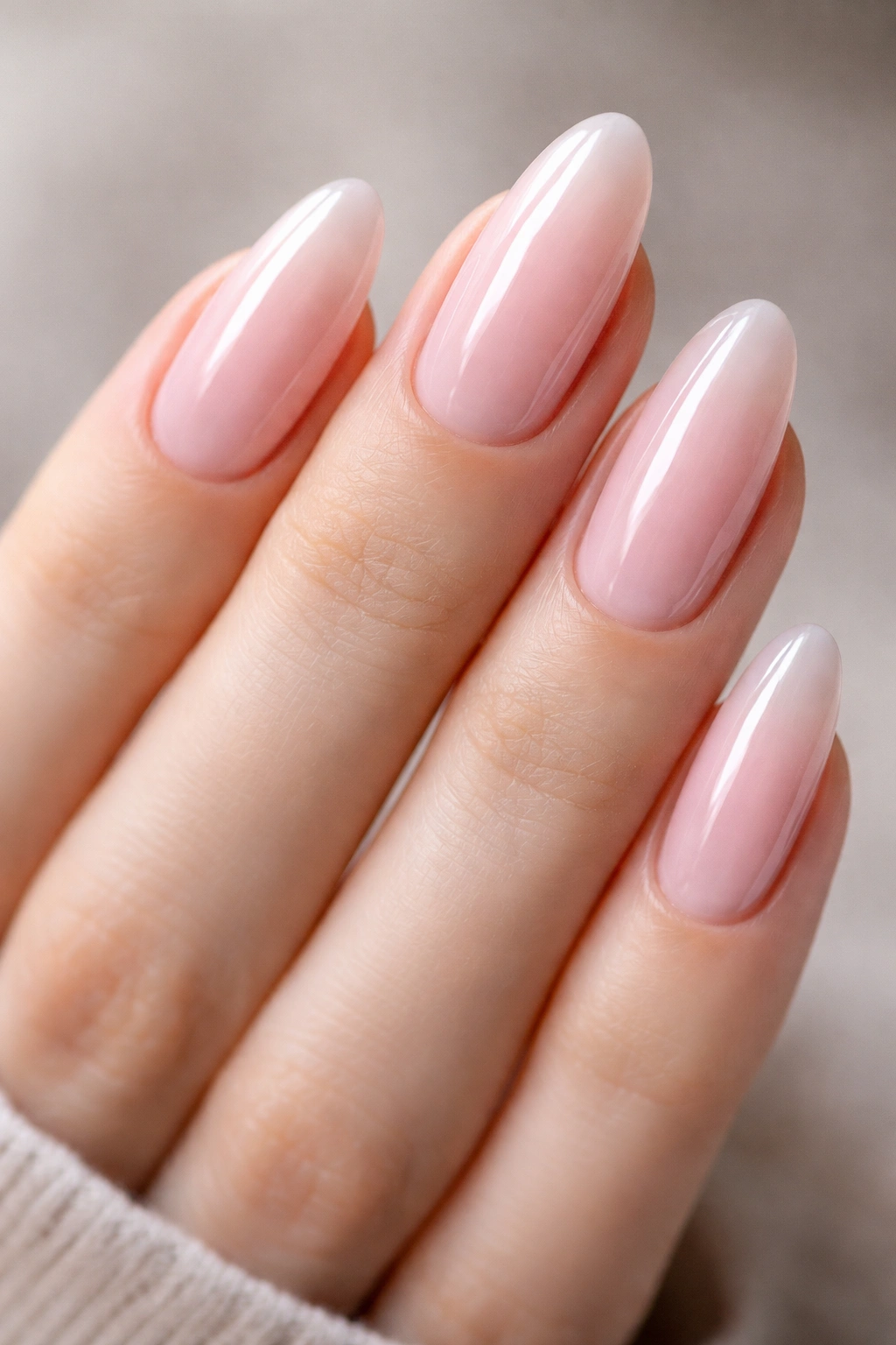 Close-up of tapered oval nails with sheer baby pink gloss