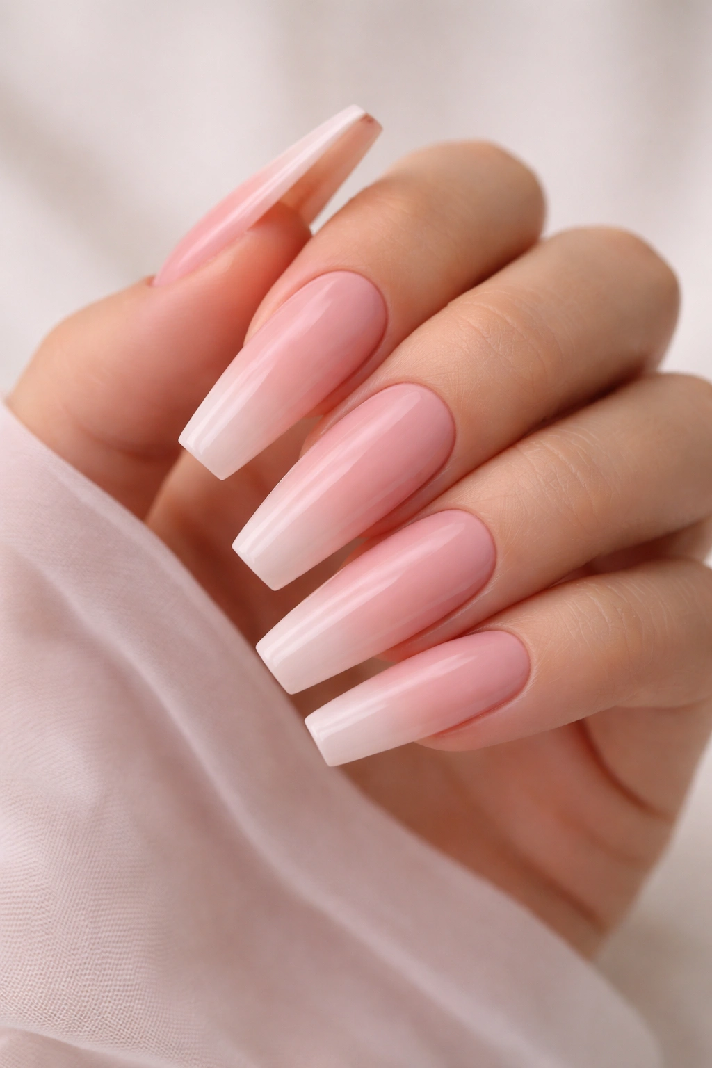 Close-up of coffin nails in ballet pink with nude ombre tips
