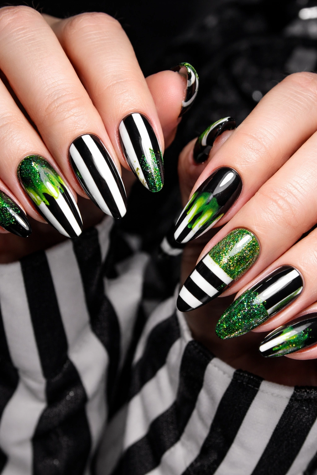 Hands with black and white striped nails and green accents