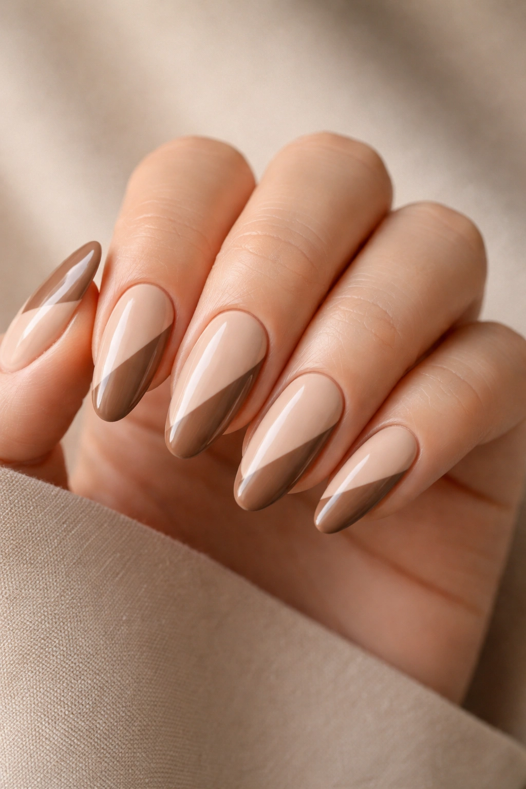 Close-up of long oval nails split beige and mocha diagonally