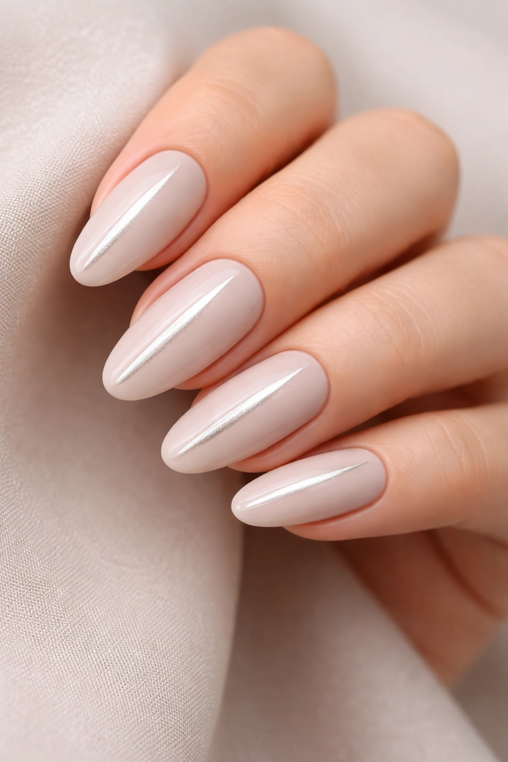 Close-up of cool-toned beige oval nails with a single vertical brushstroke on each nail