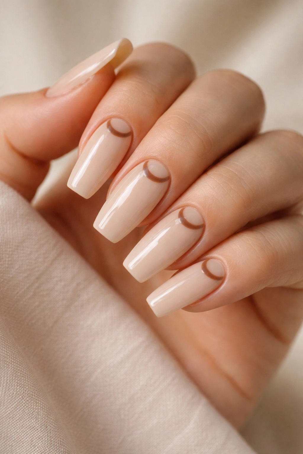 Close-up of medium coffin nails with beige base and brown crescent moon details at cuticle