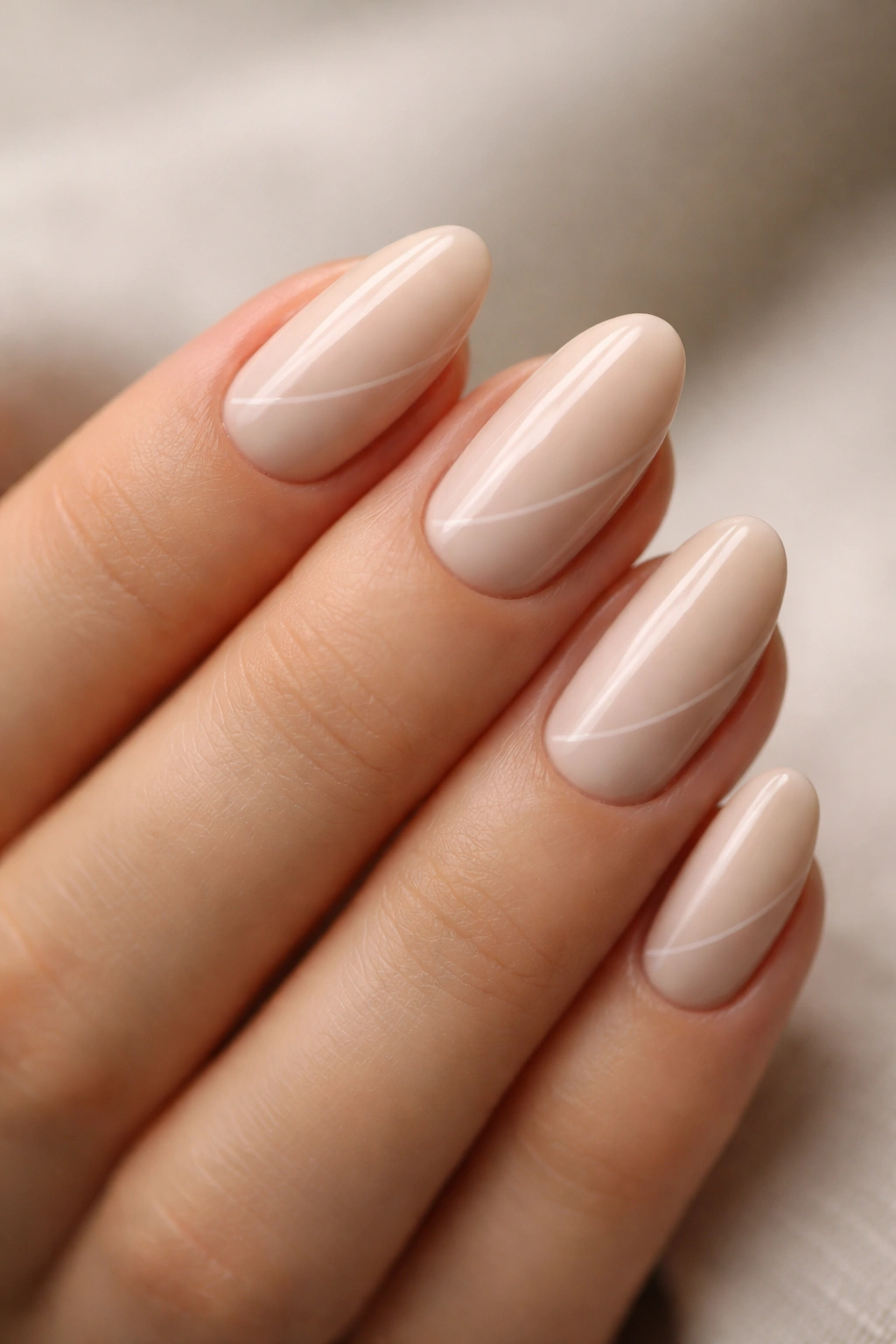 Beige almond nails with a barely-there line art design