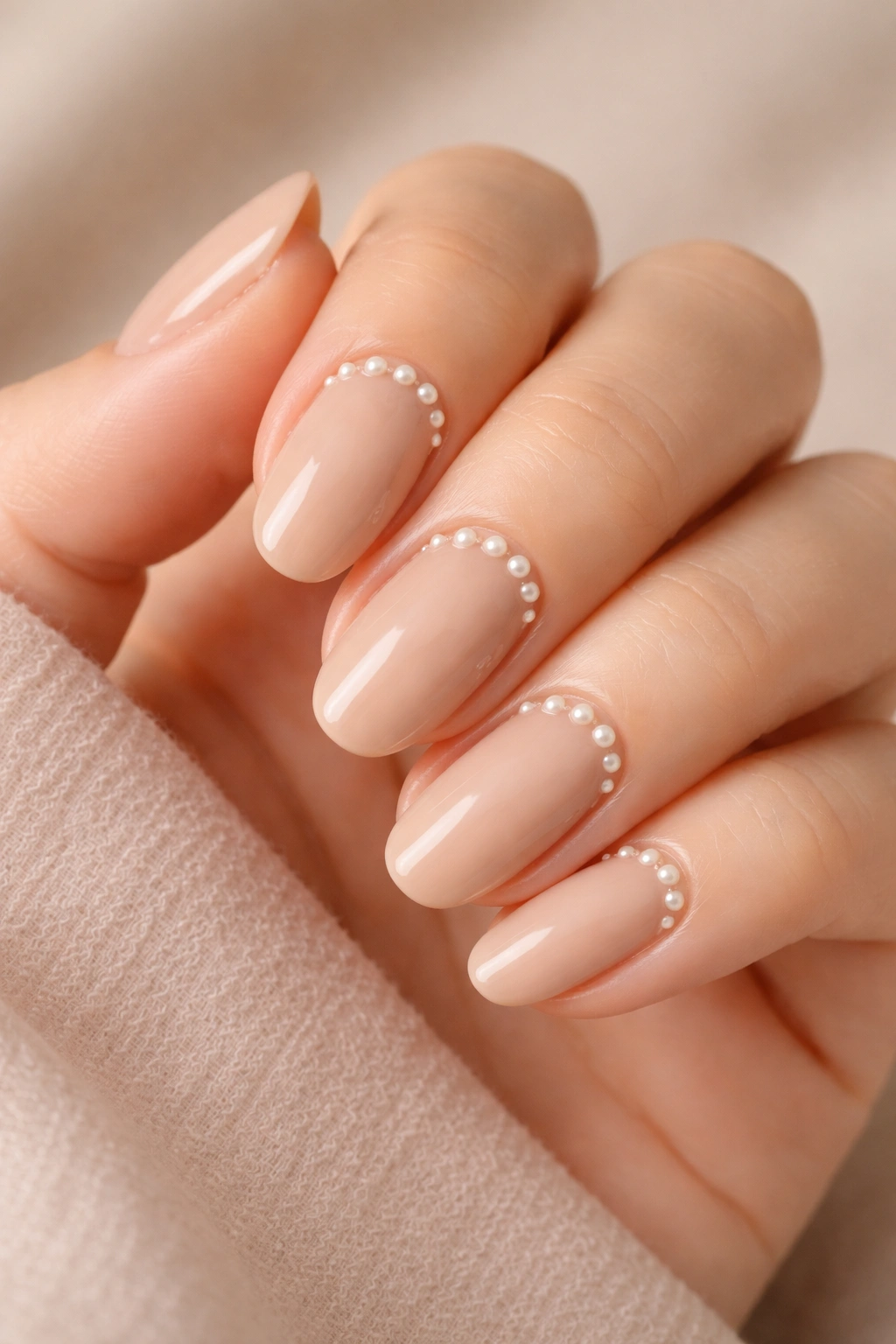 Warm latte beige nails with pearl embellishments near cuticles