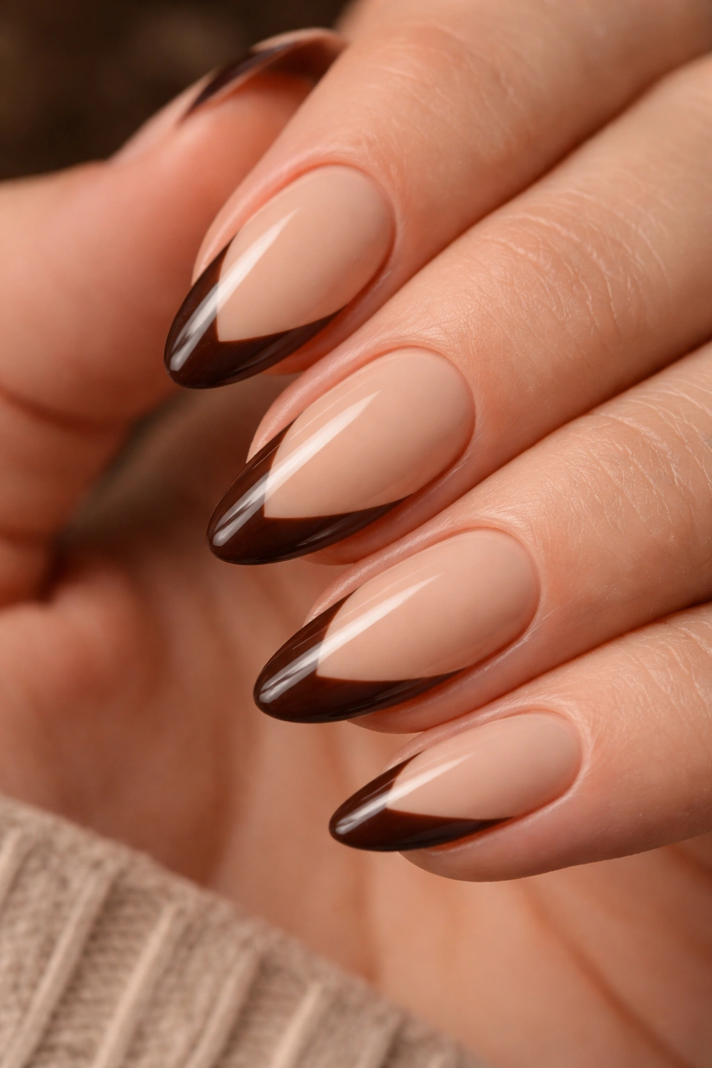 Close-up of beige nails with dark brown slanted French tips