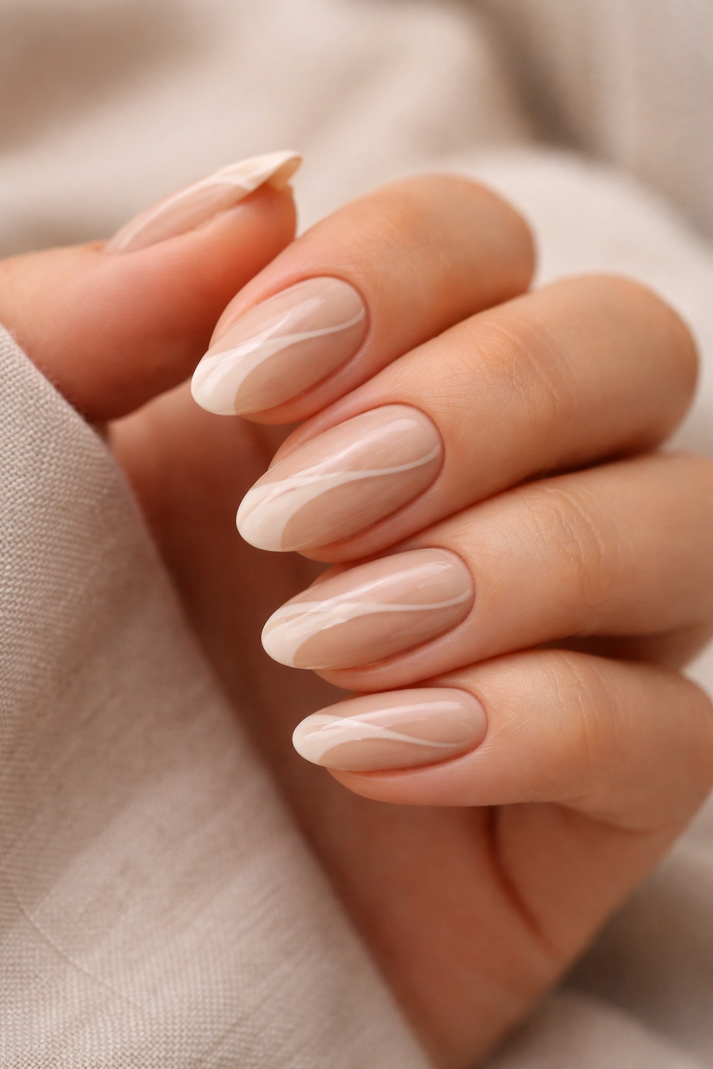 Close-up of beige and nude swirl almond nails