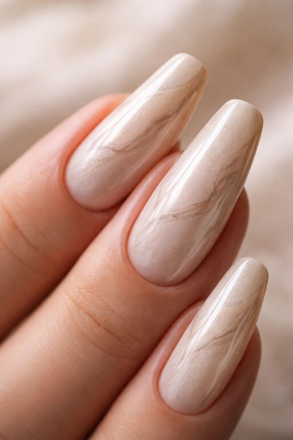 Beige pearl ballerina nails with tonal marble veins on hand