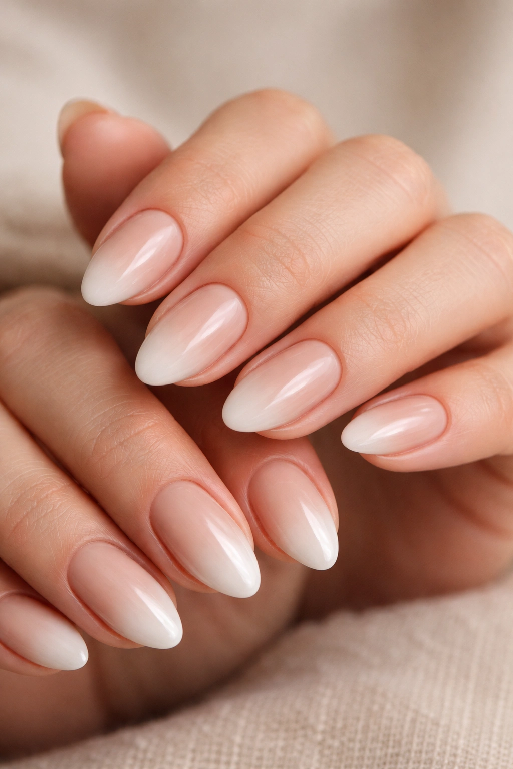 Close-up of beige-to-white baby boomer almond nails with seamless blend