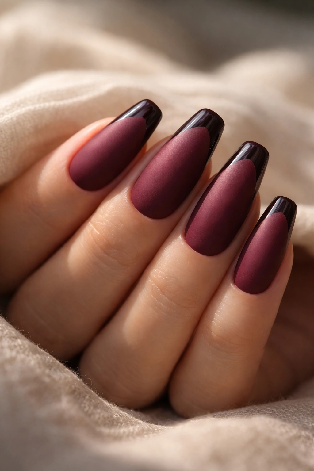 Close-up of berry matte ballerina nails with glossy crescent tips