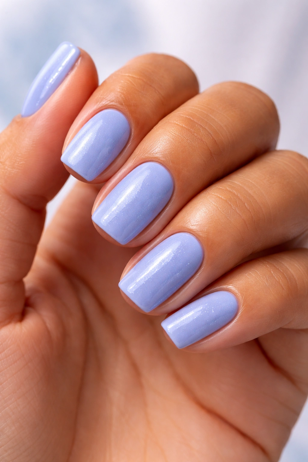 Close-up of nails painted Bikini So Teeny cornflower blue with shimmer