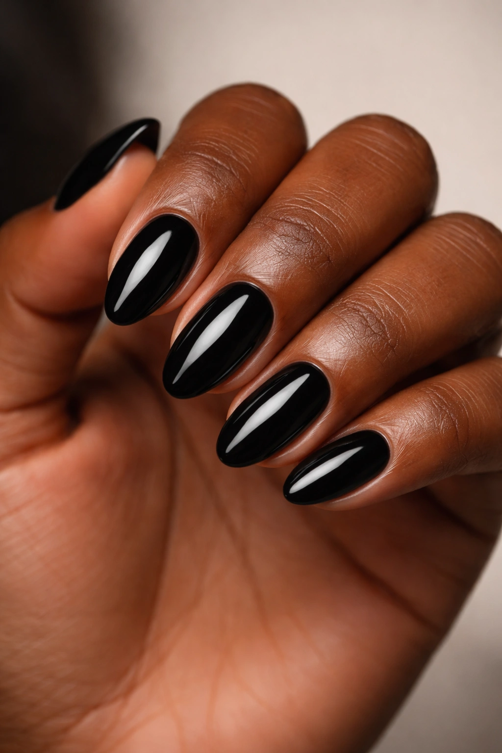 Close-up of black short almond nails with a glossy finish