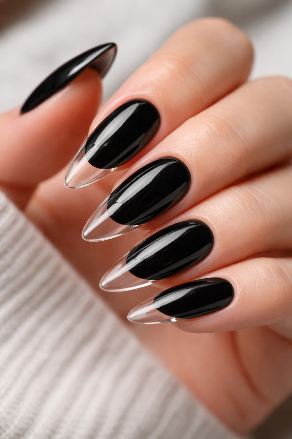 Close-up of black almond nails with clear tips