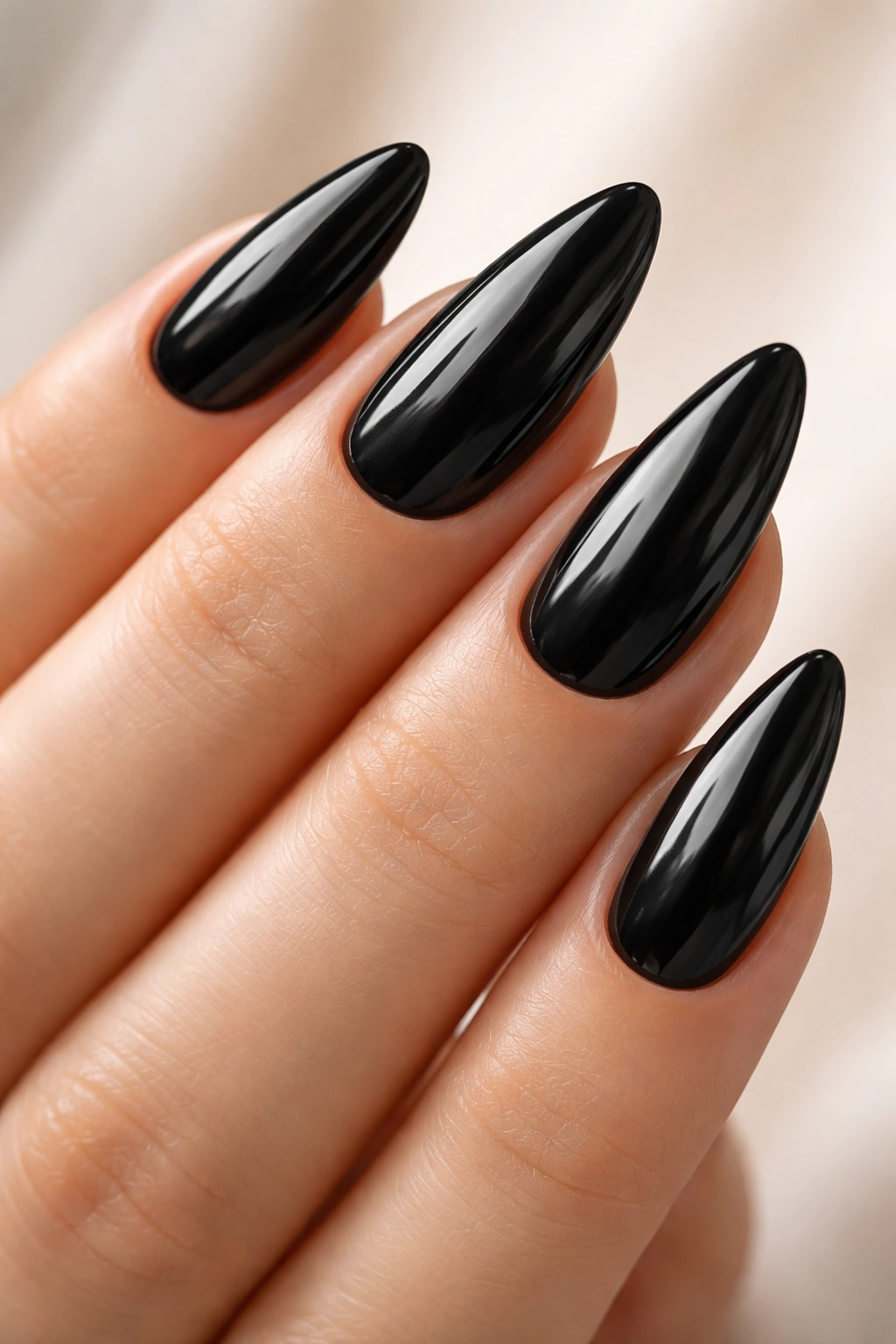 Glossy black almond-shaped nails on a hand