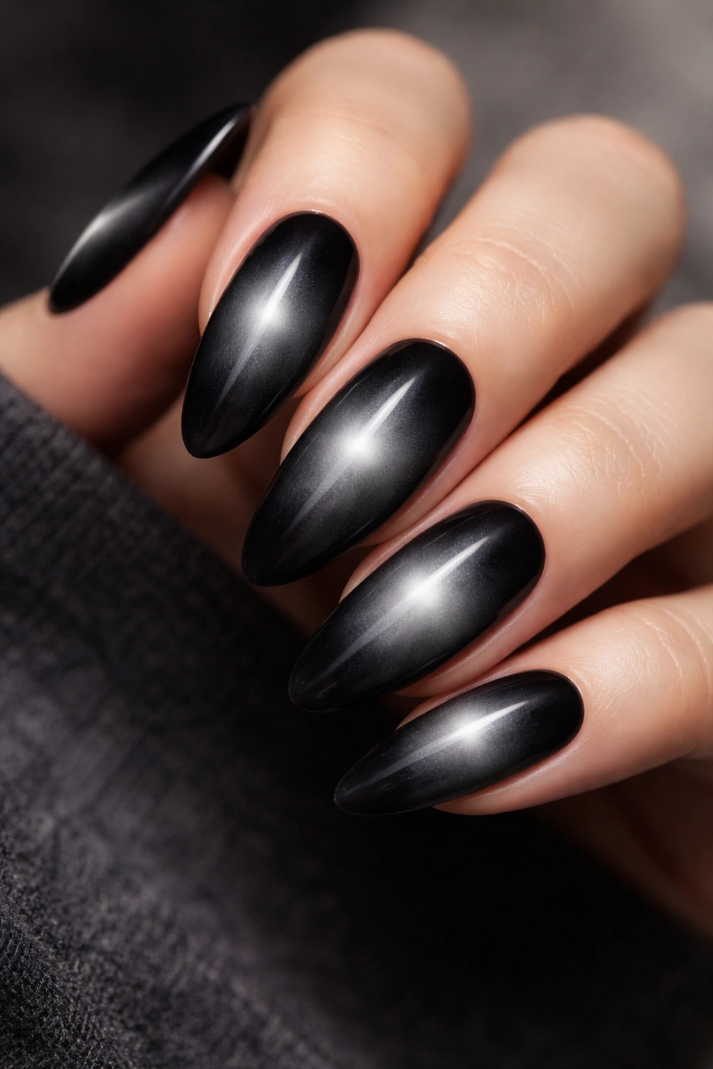 Close-up of black aura nails showing center gradient on long almond nails