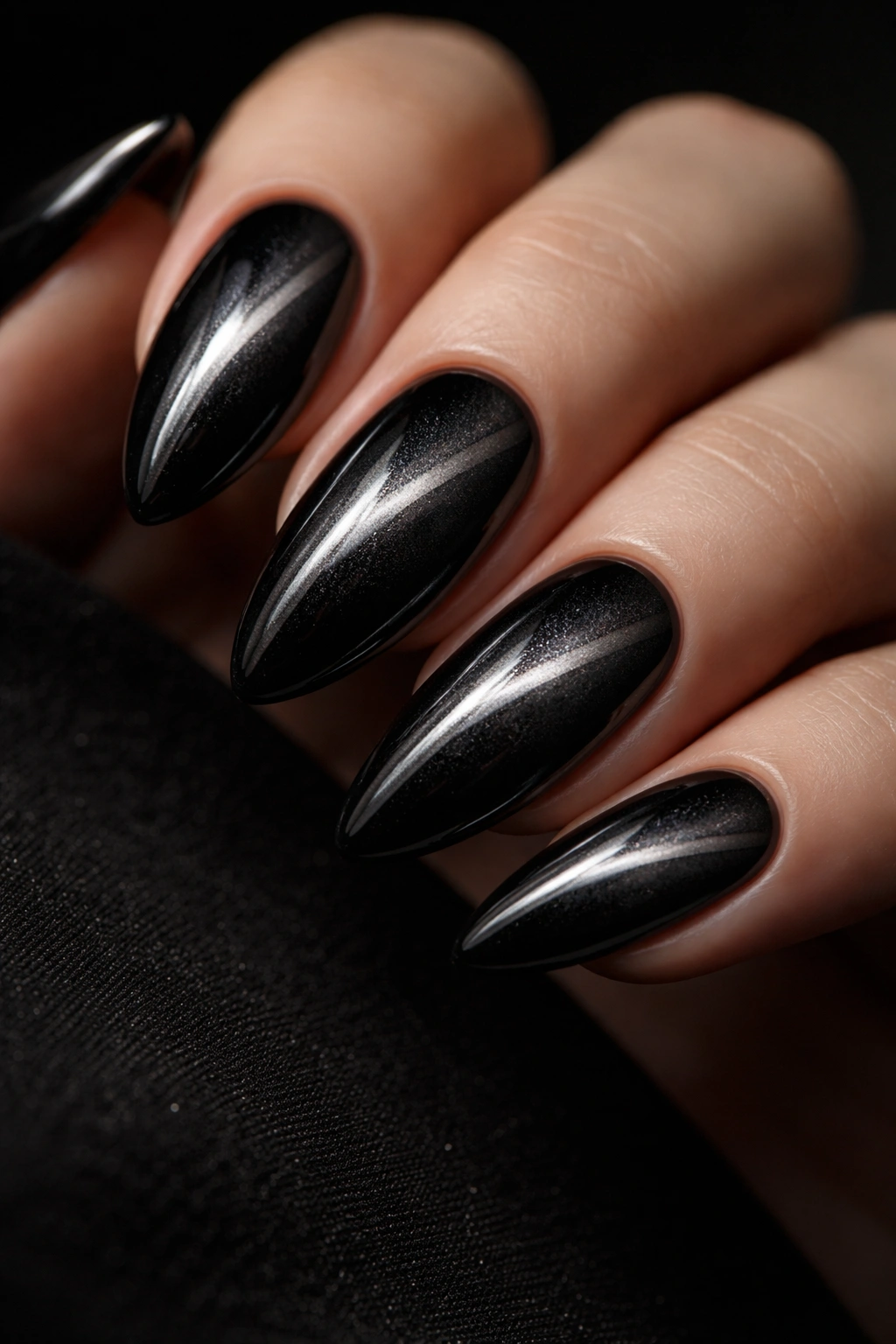 Close-up of black cat-eye nails with a shimmering magnetic stripe