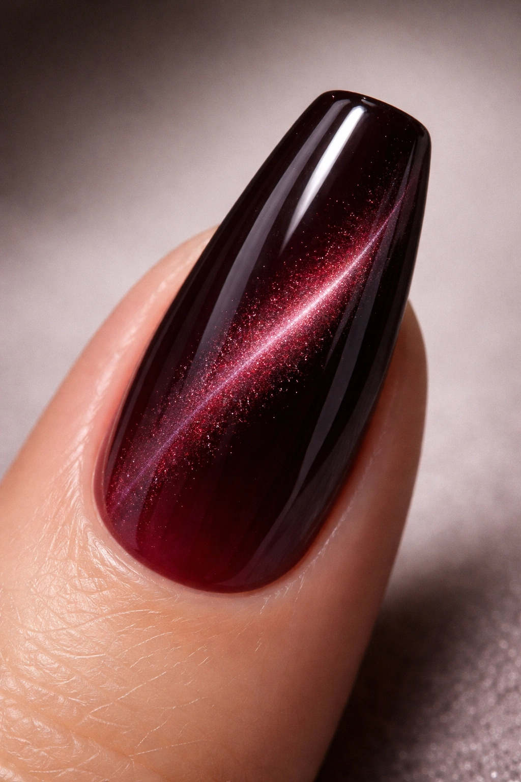 Close-up of black cherry jelly cat-eye nail with deep berry base