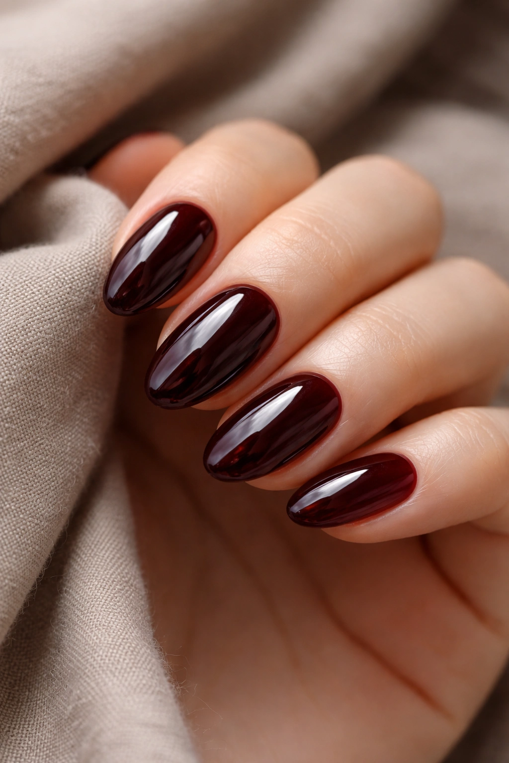 Close-up of black cherry short almond nails with jelly finish