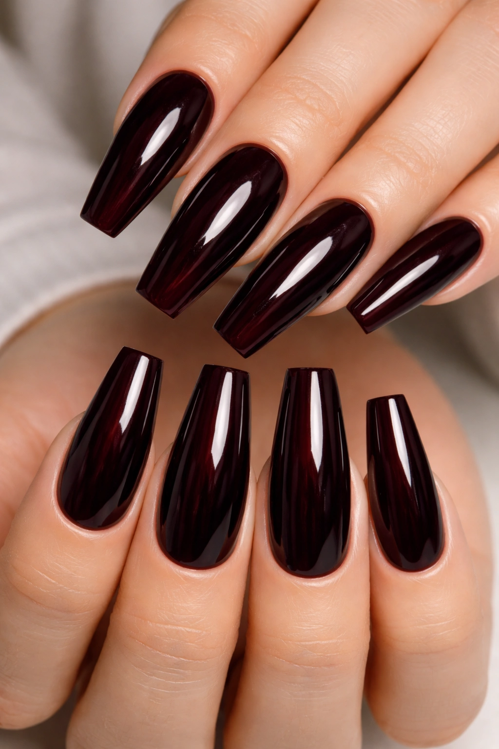 Close-up of long coffin nails in deep black-cherry shade.