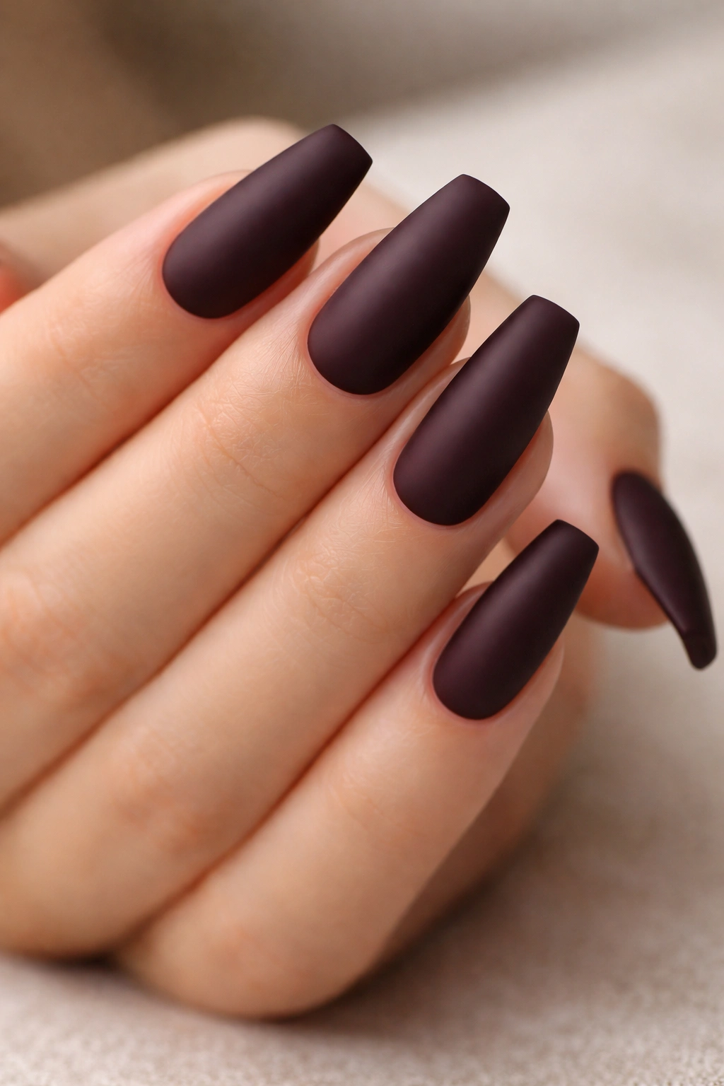 Close-up of black cherry matte nails on medium ballerina nails