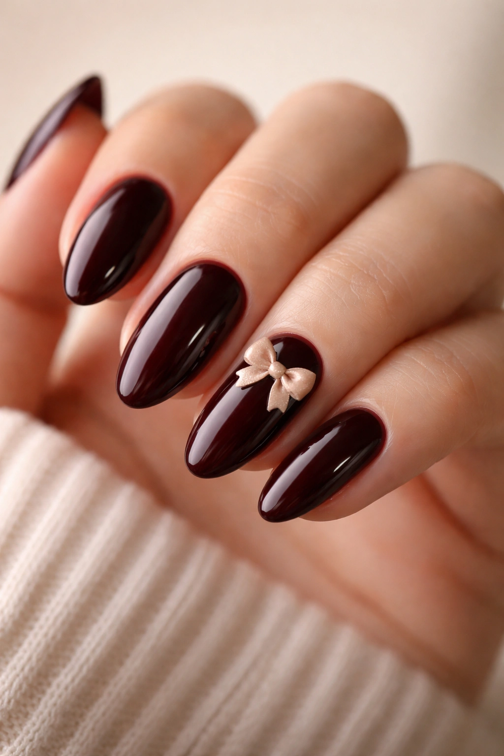 Deep cherry nails with tiny nude bow accent