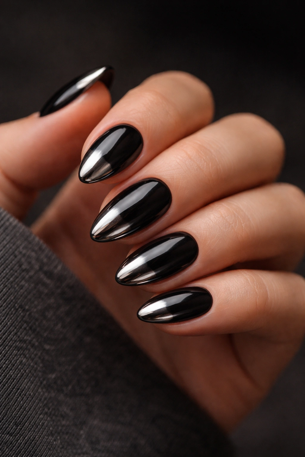 Short almond nails with black base and gunmetal chrome tips