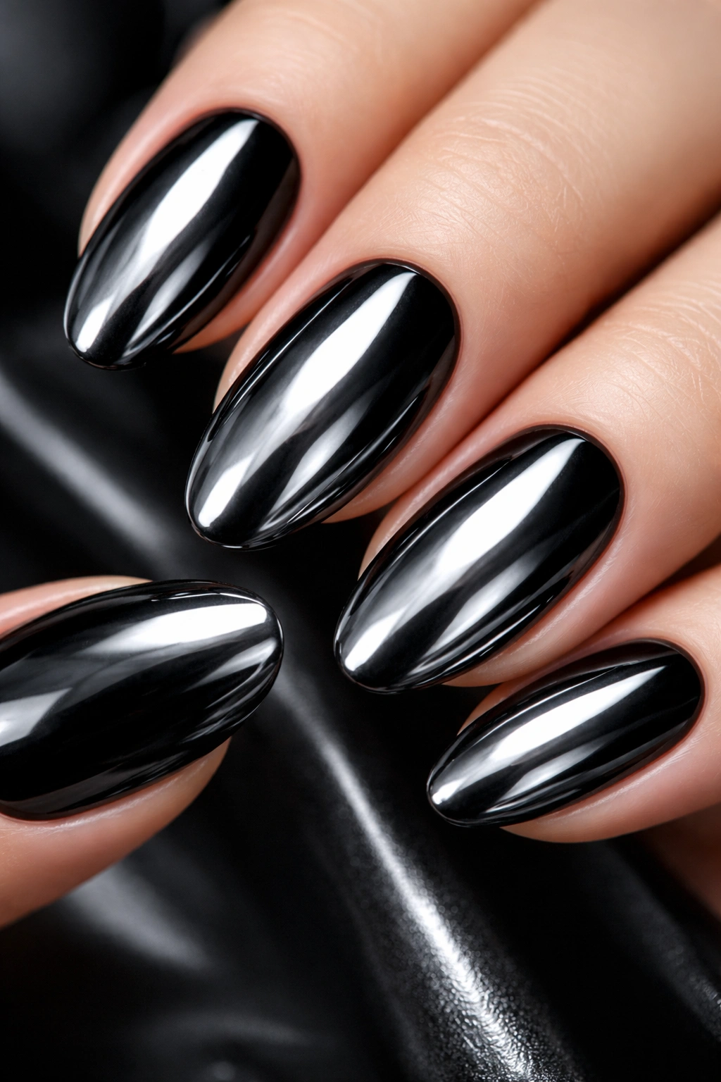 Close-up of black nails with chrome mirror powder for a reflective finish