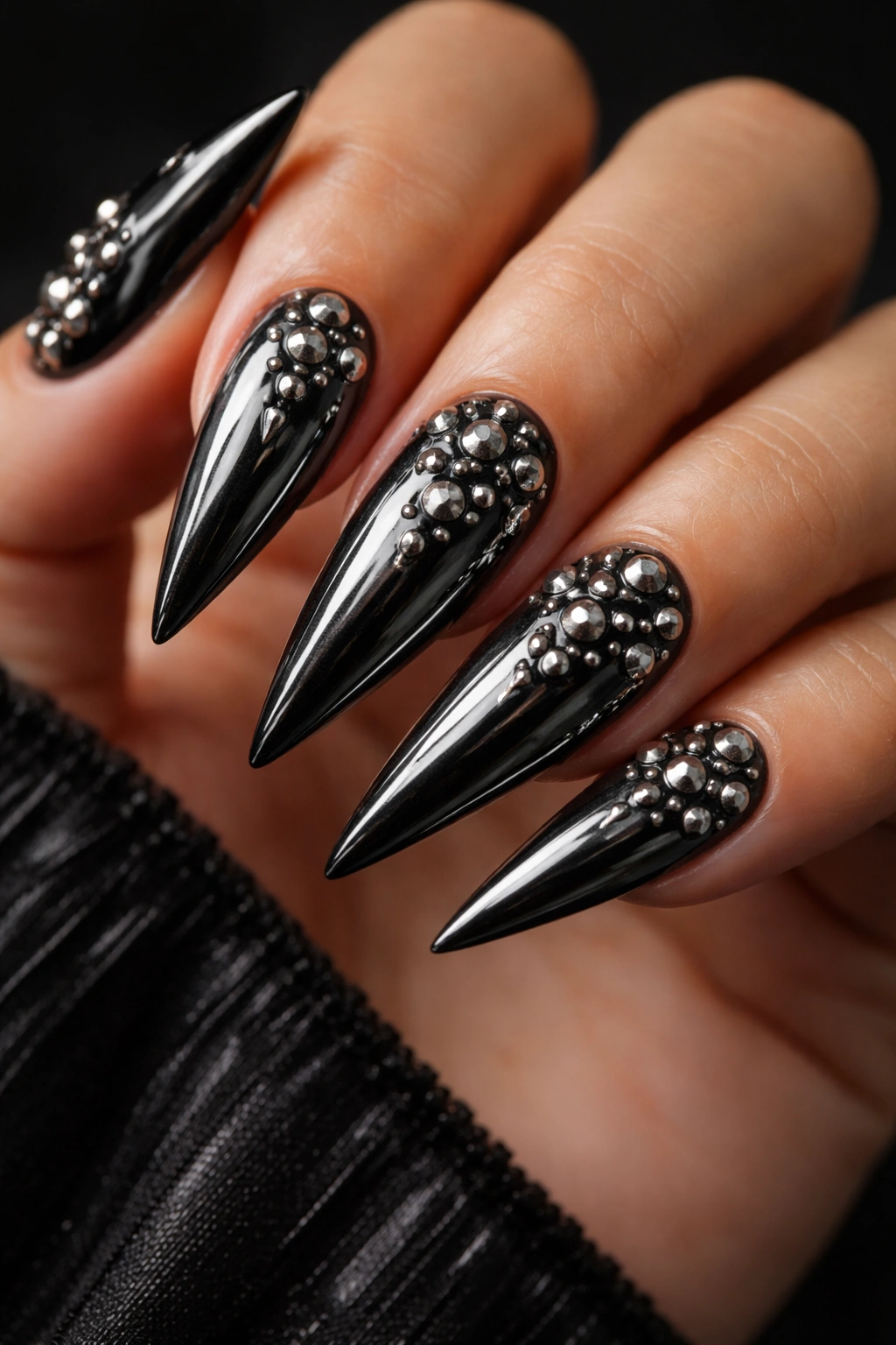 Black chrome nails with metallic studs in a geometric arrangement