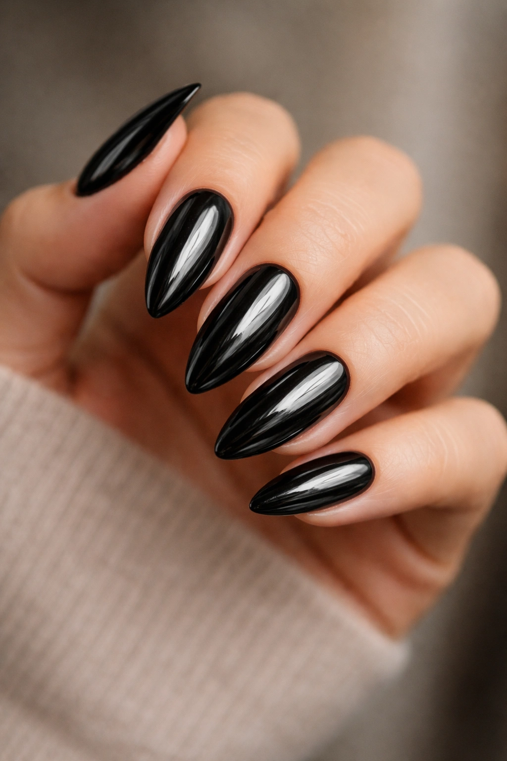 Close-up of black chrome almond nails with obsidian mirror finish