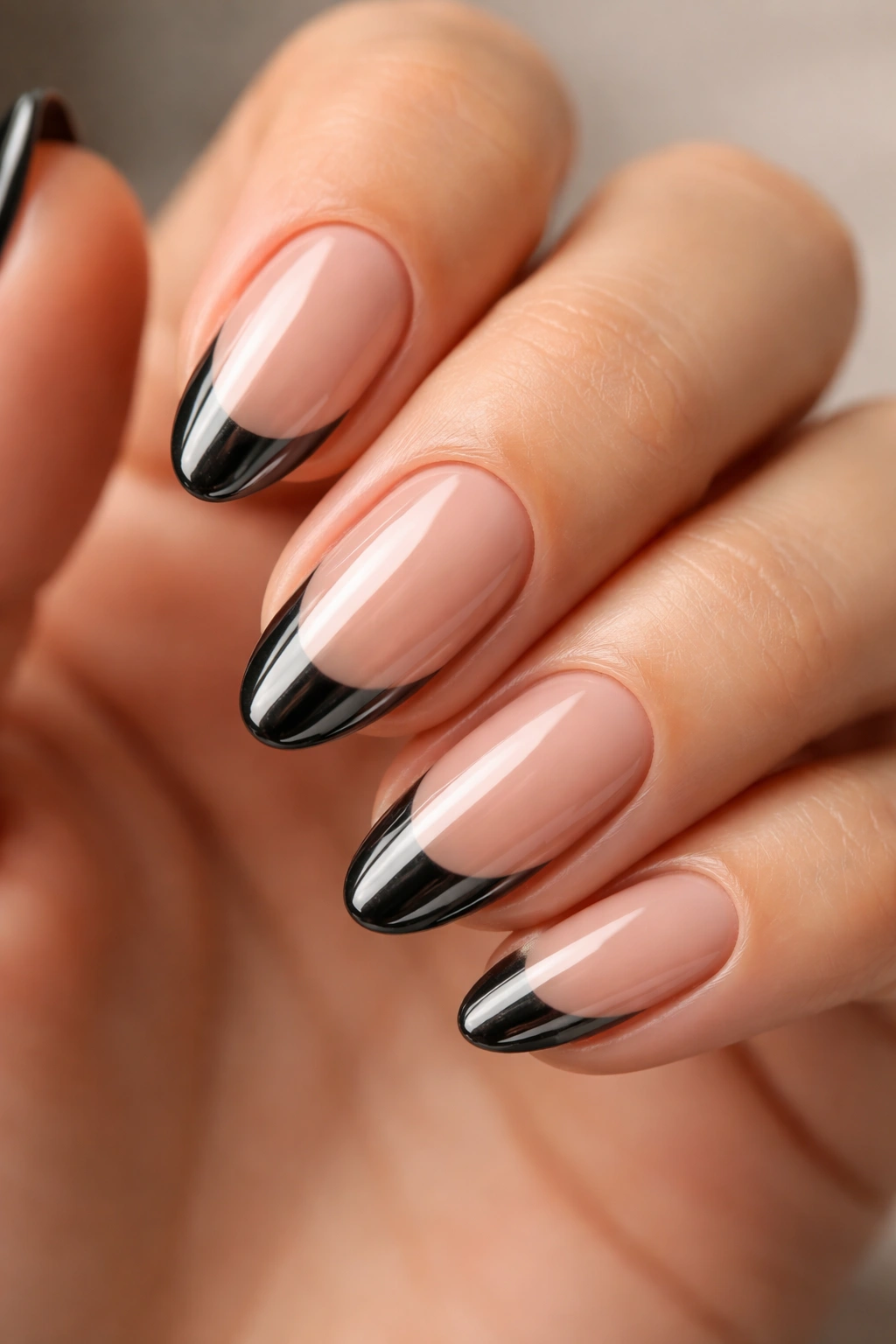 Close-up of black chrome French tip nails on short almond shape