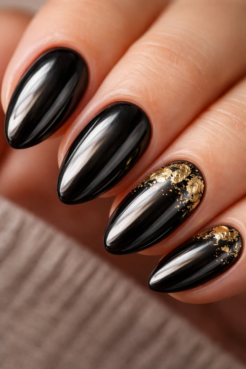 Short almond nails with black chrome and gold foil accents