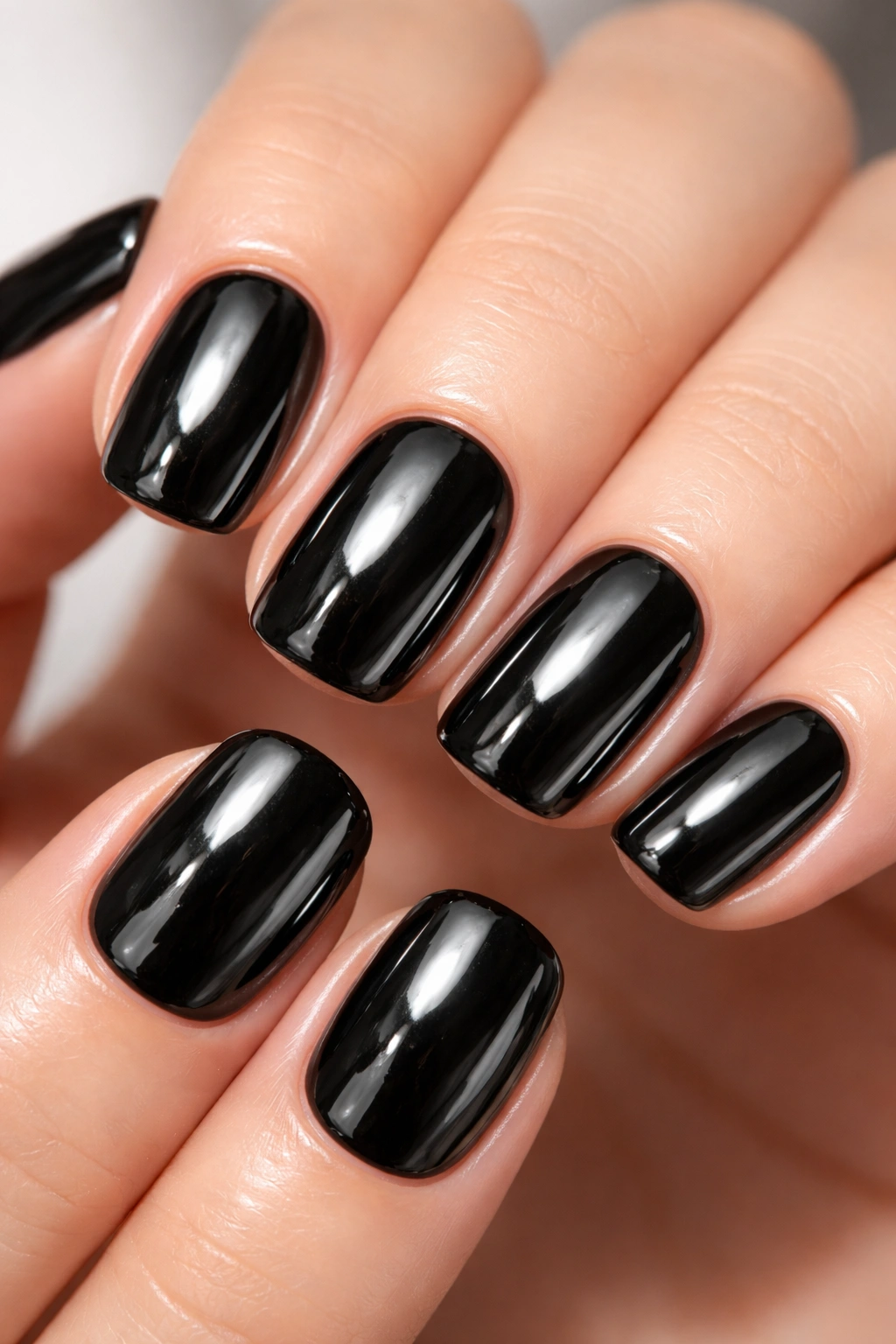 Close-up of short squoval nails with black chrome mirror finish