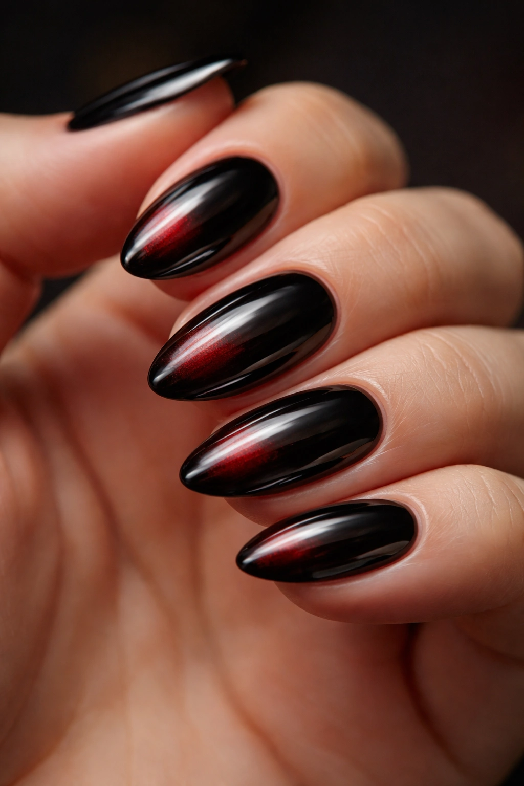 Nails with black chrome showing deep red undertones in certain light