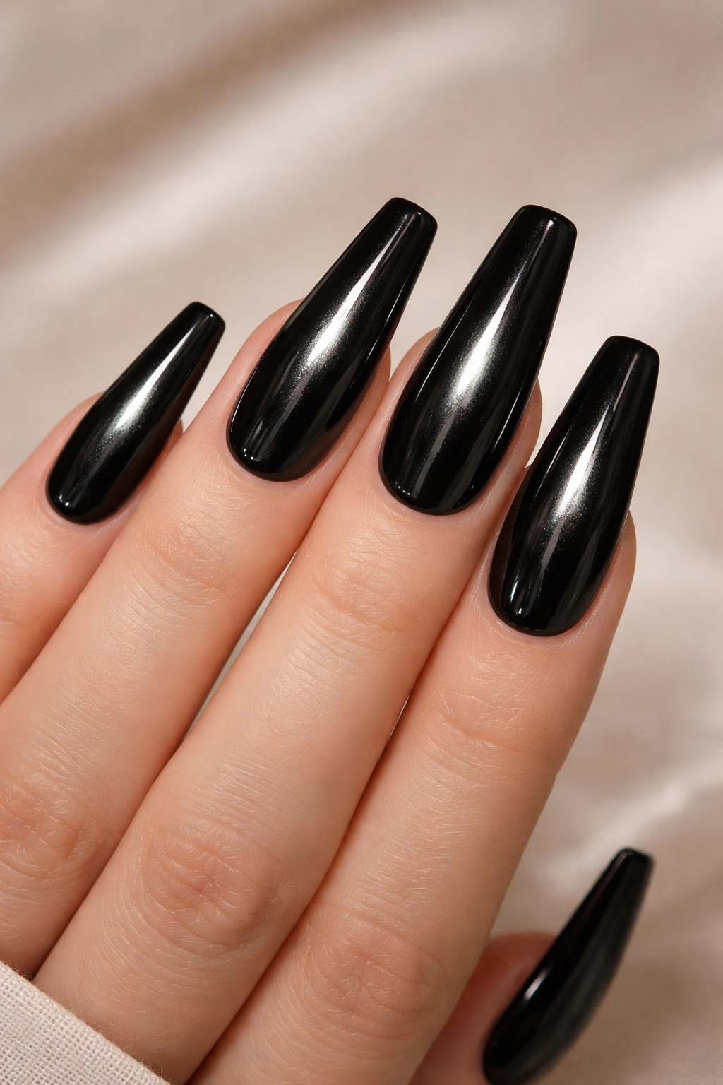 Close-up of long black coffin nails showing a vertical cat-eye gel line for depth