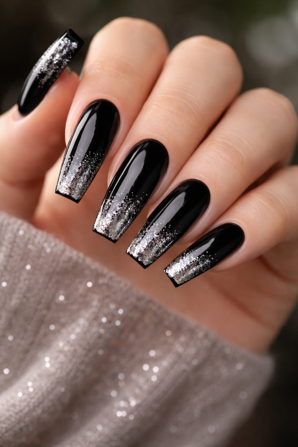 Close-up of black coffin nails with silver glitter on a hand