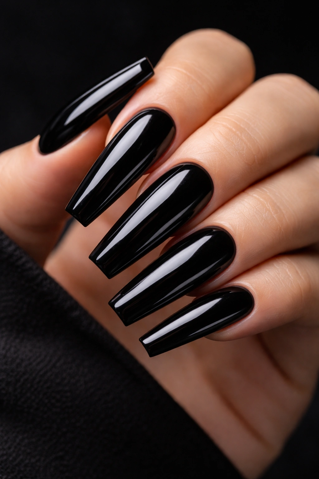 Deep black glossy coffin nails on a hand