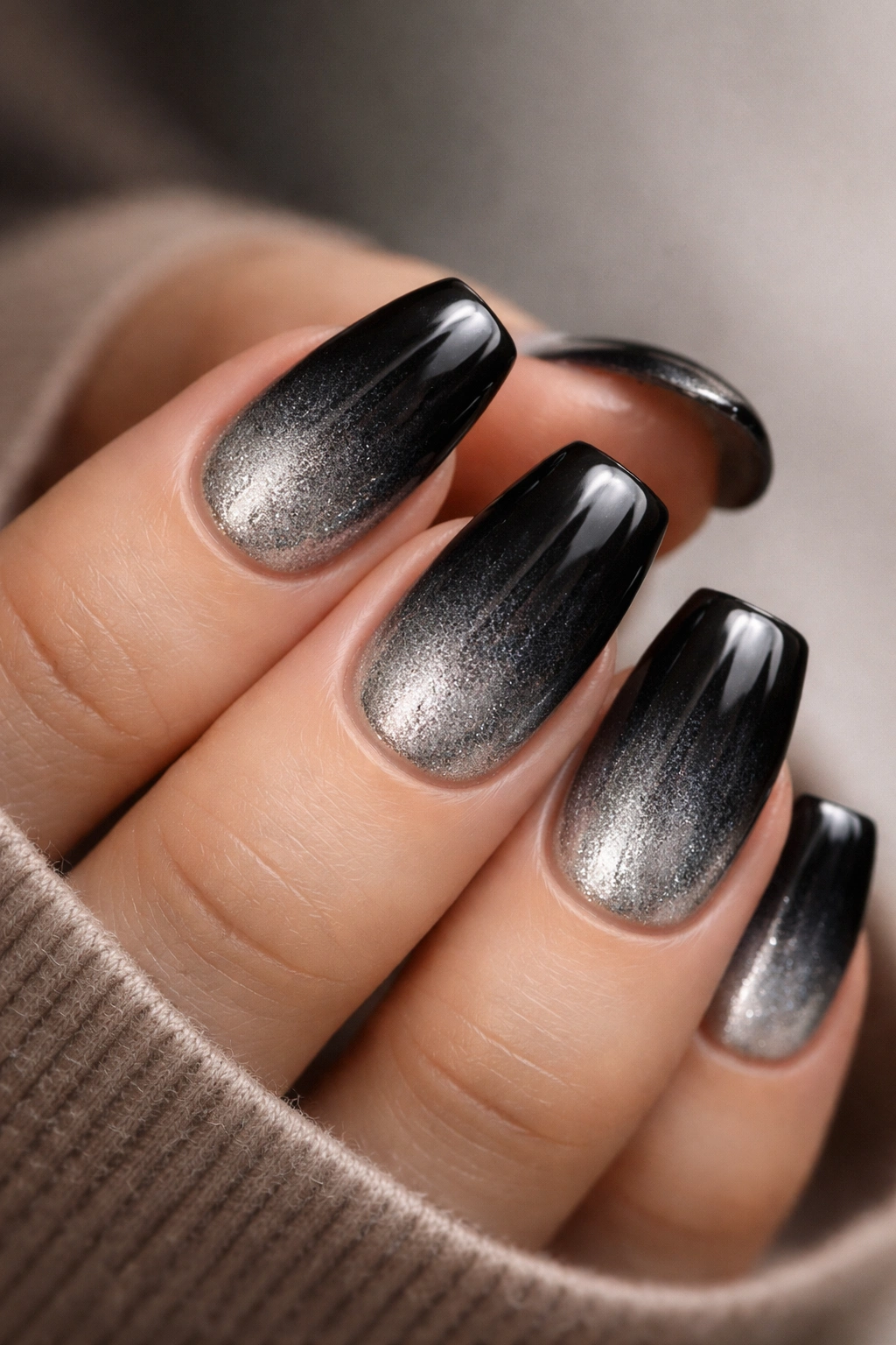Close-up of black duck nails with black to silver ombre on short nails
