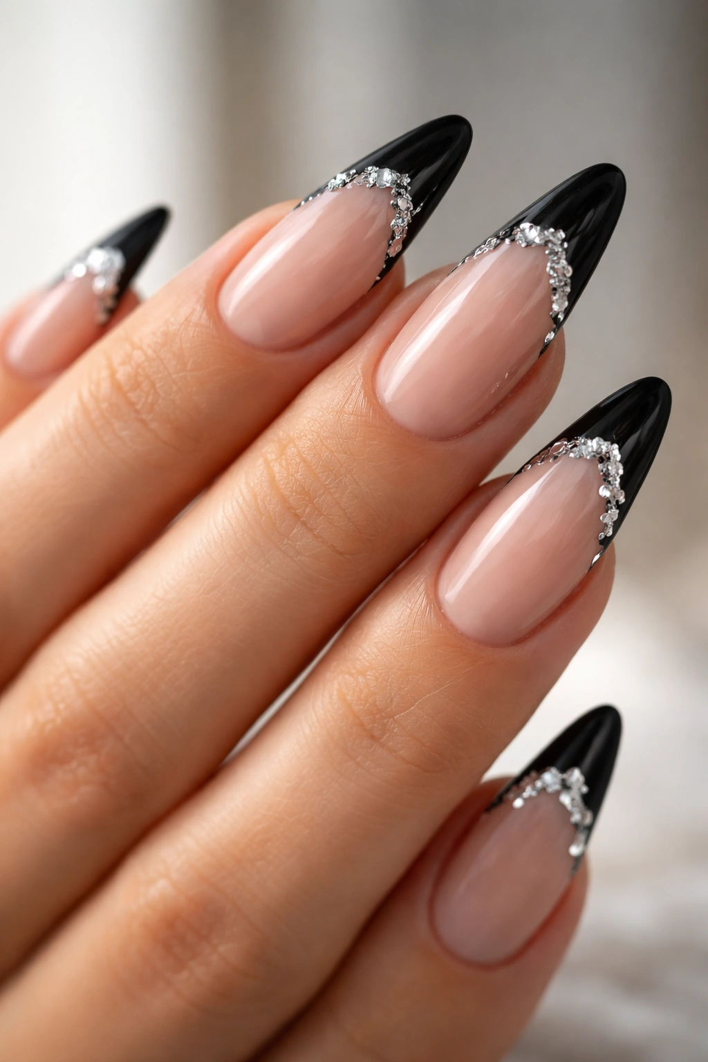 Long almond nails with black French tips and silver foil accents