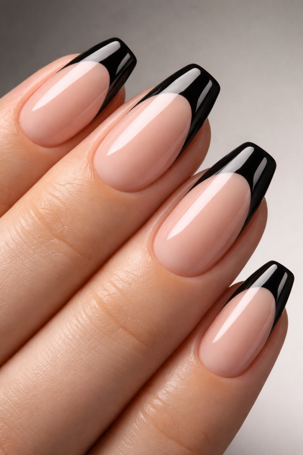 Nude nail with glossy black French tips.