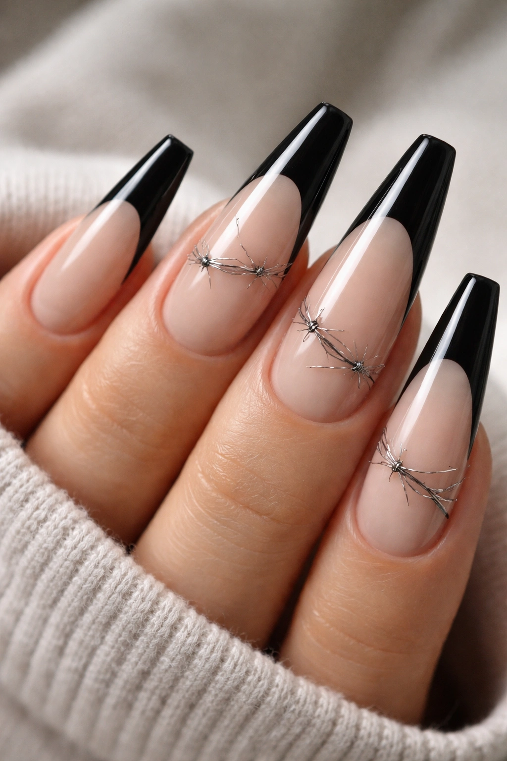 Close-up of black French tips with fine barbed-wire line work on ballerina nails