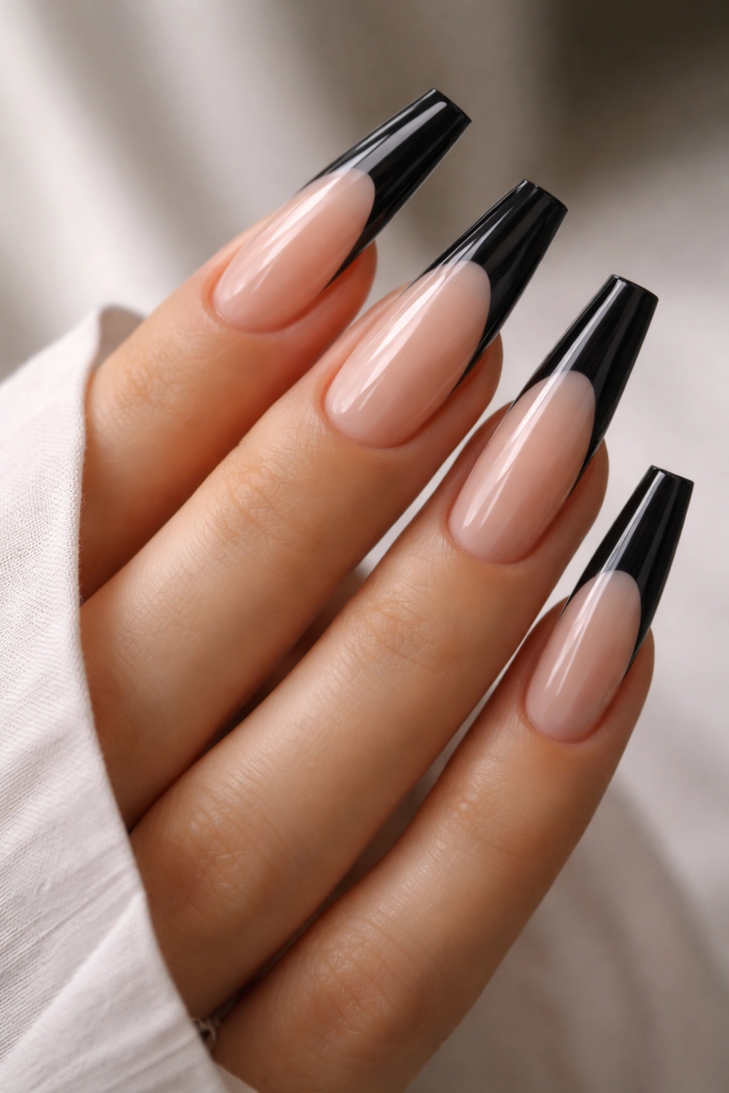 Coffin nails with black tips on a clear base in a close-up