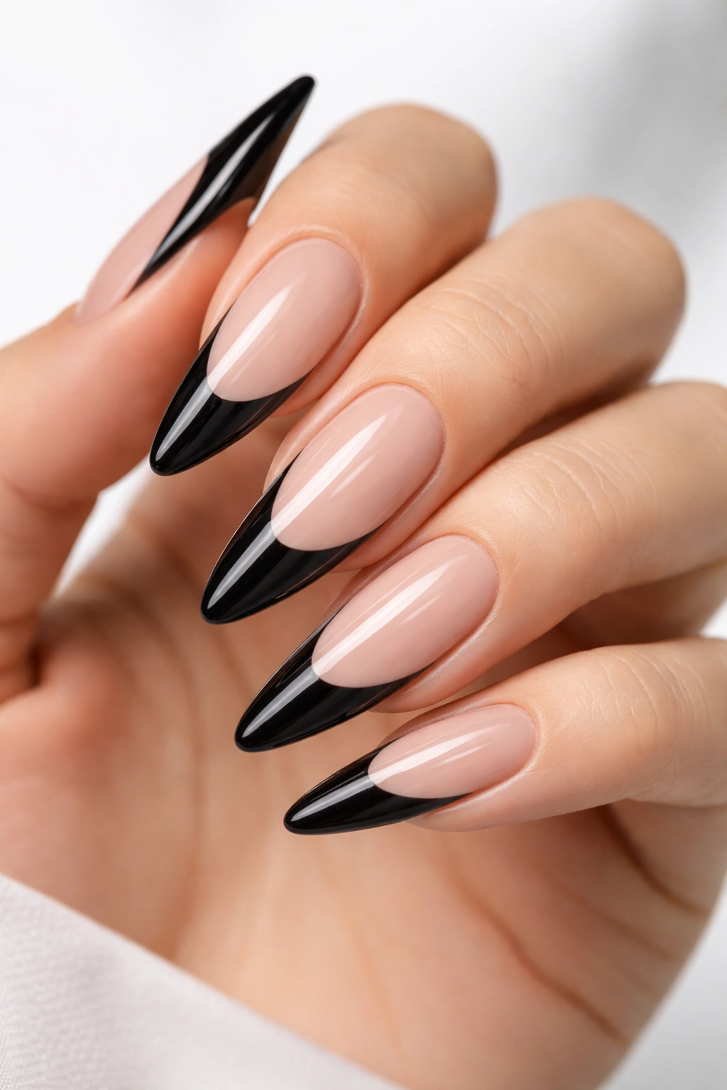 Close-up of long almond nails with bold black tips and dramatic curve