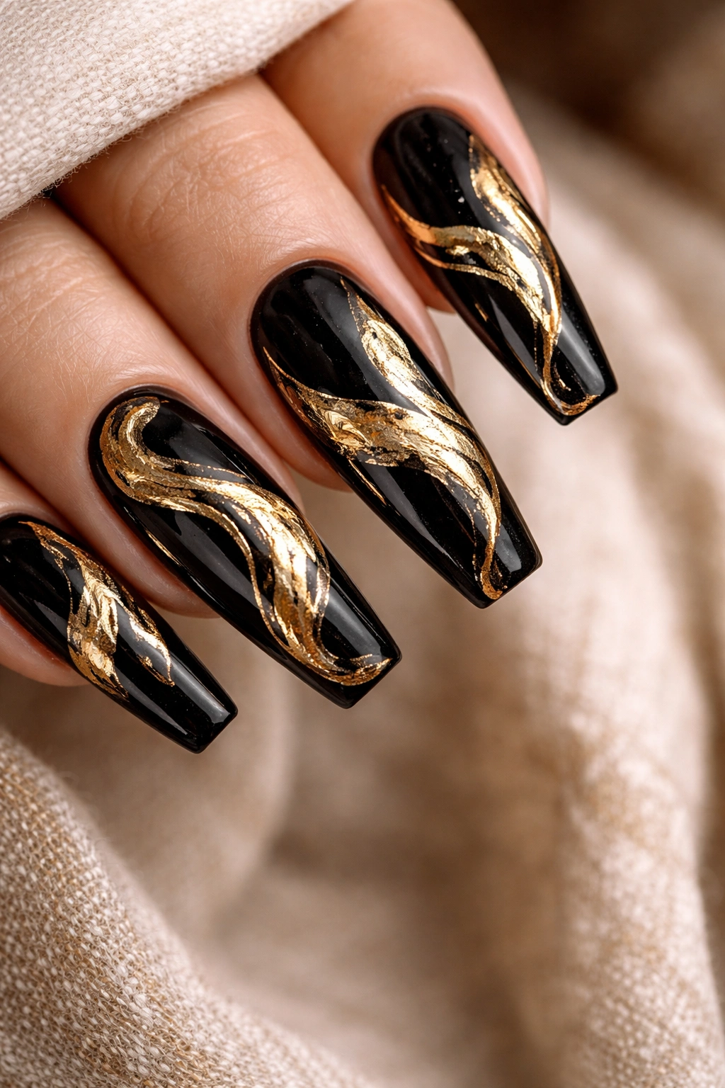 Close-up of coffin nails featuring black base with gold foil swirls