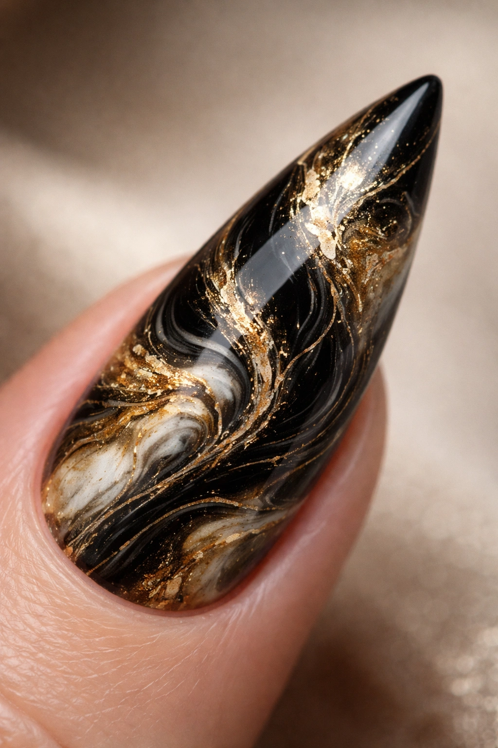 Black and gold marble stiletto nail close-up