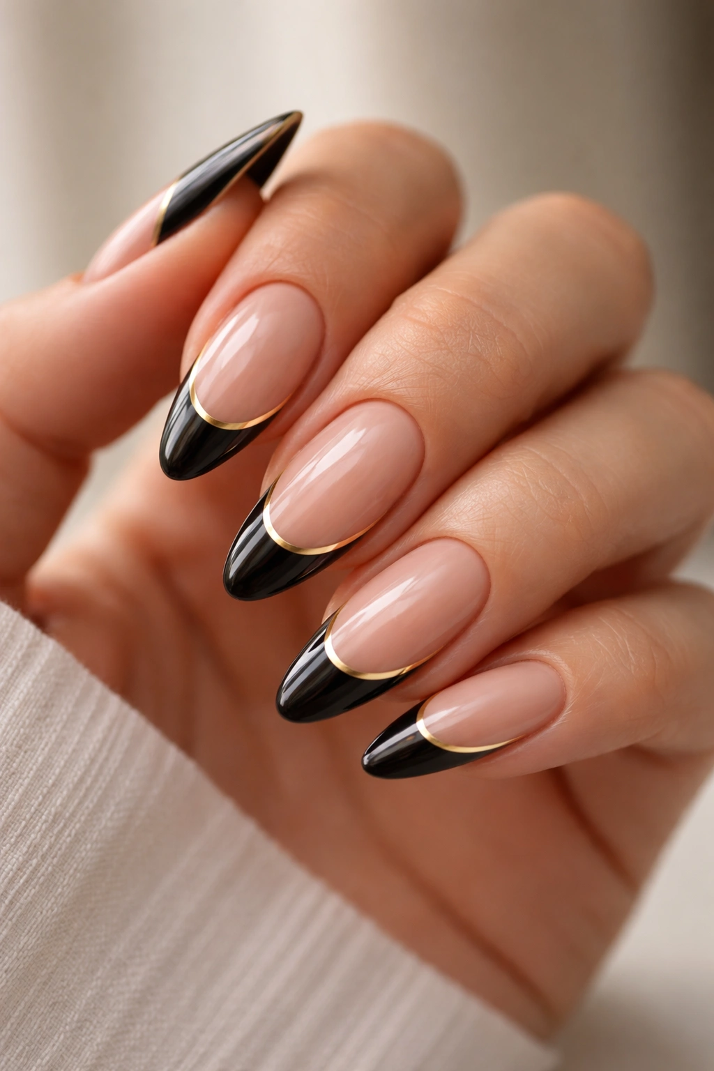 Almond nails with black tips and gold accents