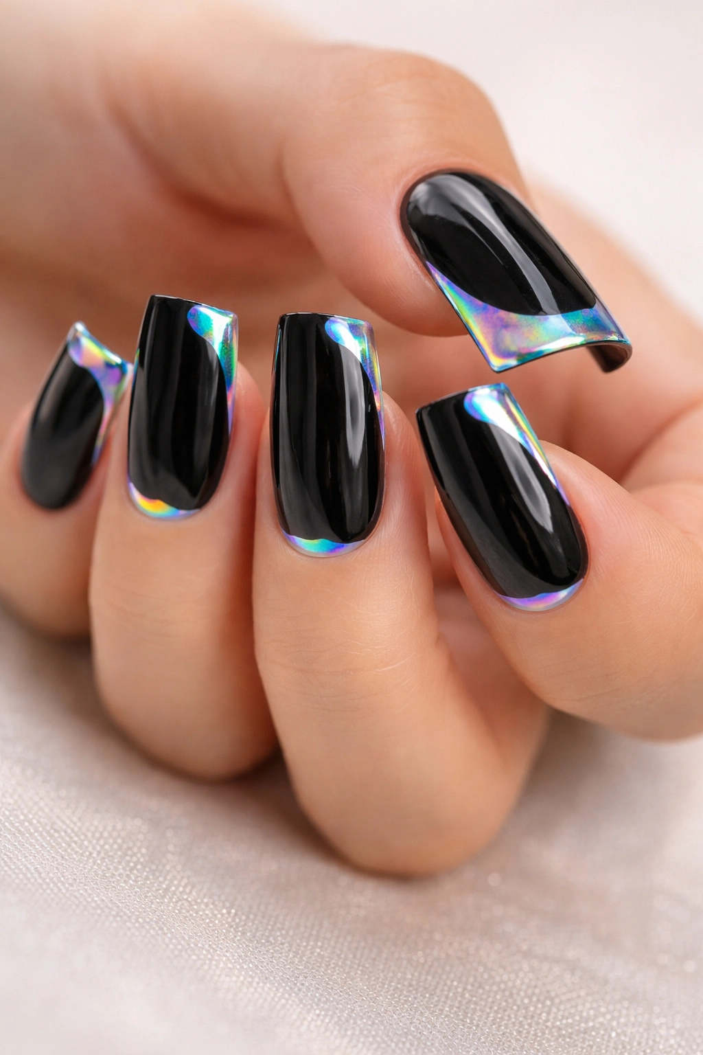 Close-up of duck-shaped nails with black tips and holographic accents showing rainbow reflections