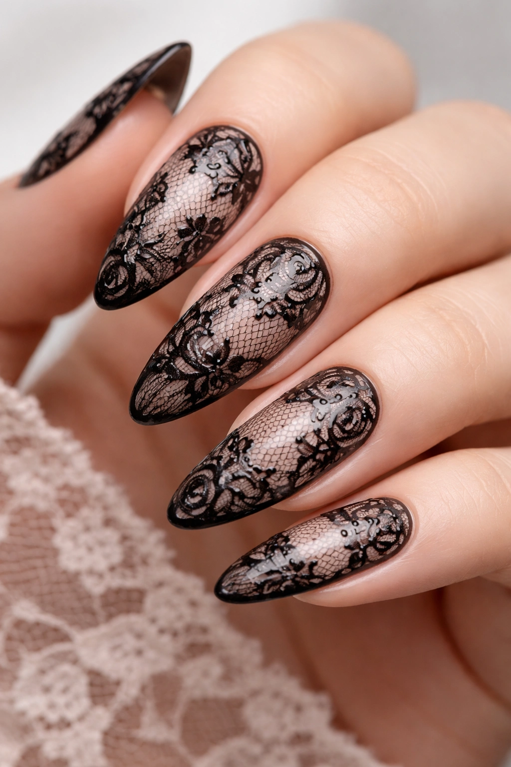 Nails with black lace nail art on a nude base