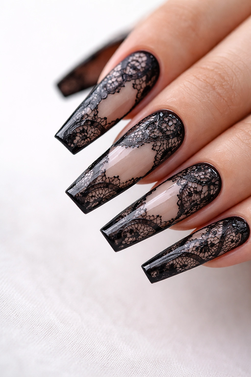 Close-up of nails with black lace panels over sheer nude on ballerina nails