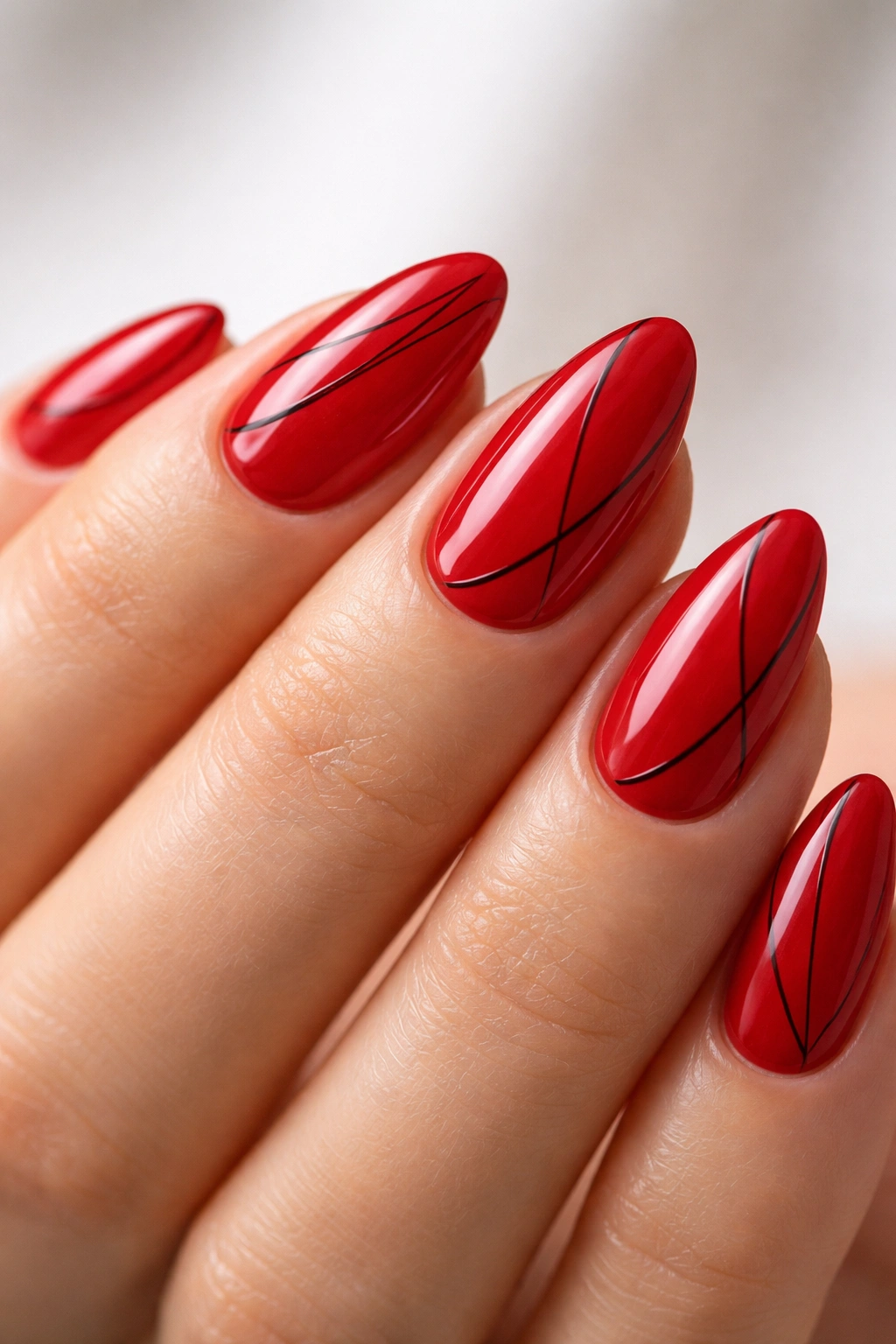 Red almond nails with thin black line art.